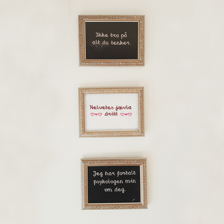 Three framed cross-stitched pieces with text