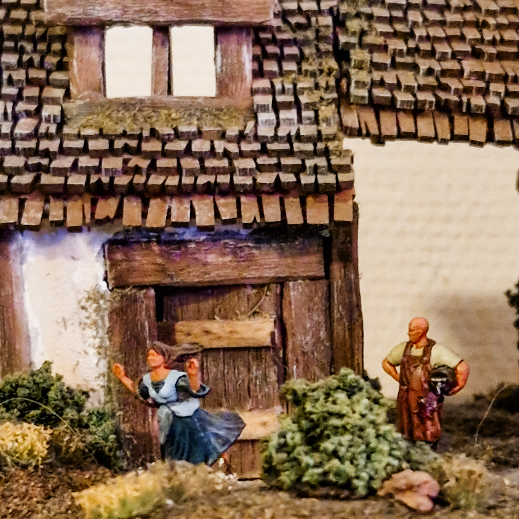 Close-up of miniature house with two miniature humans